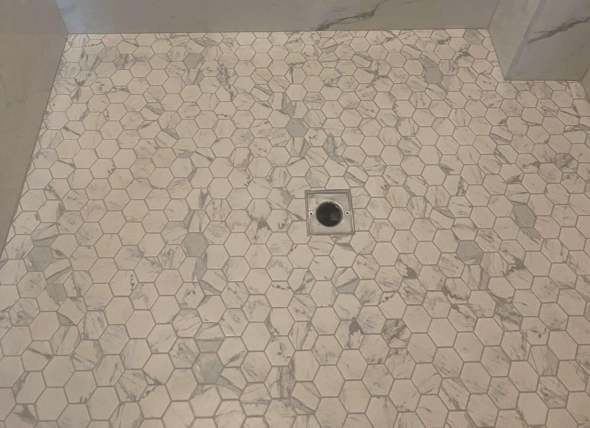 Hexagon porcelain tile flooring in a modern shower pan installation